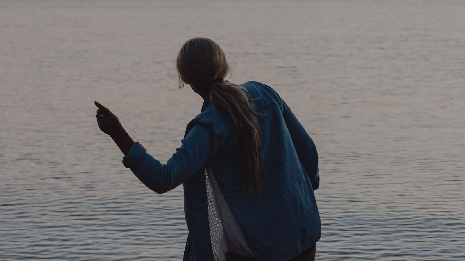 Resident skipping rocks at Barefoot Lakes community in Firestone Colorado